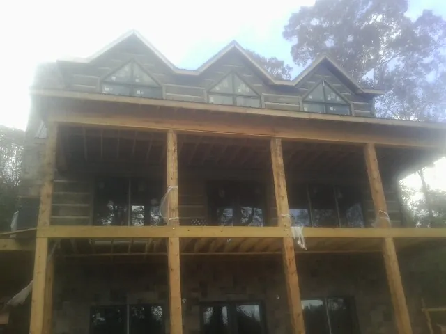 Dormers and porch framing on a large log home under construction — Roof Coating work by our crew in North Bloomfield