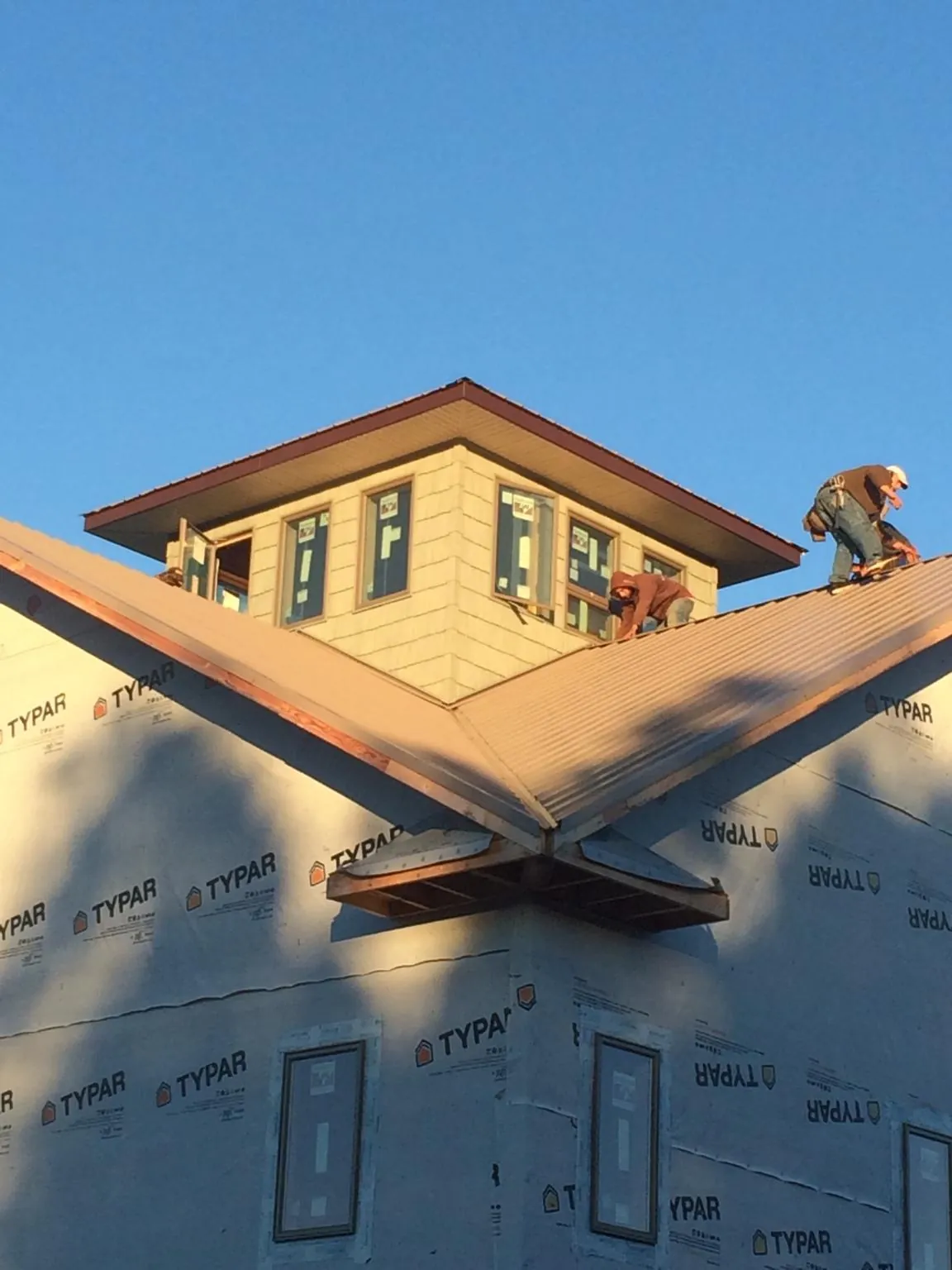 Roofers working around a rooftop cupola on a new metal roof at sunset — Roof Waterproofing in North Bloomfield by Roofing Brothers